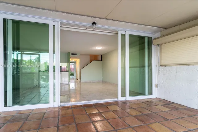 a view of a hallway with wooden floor and a living room