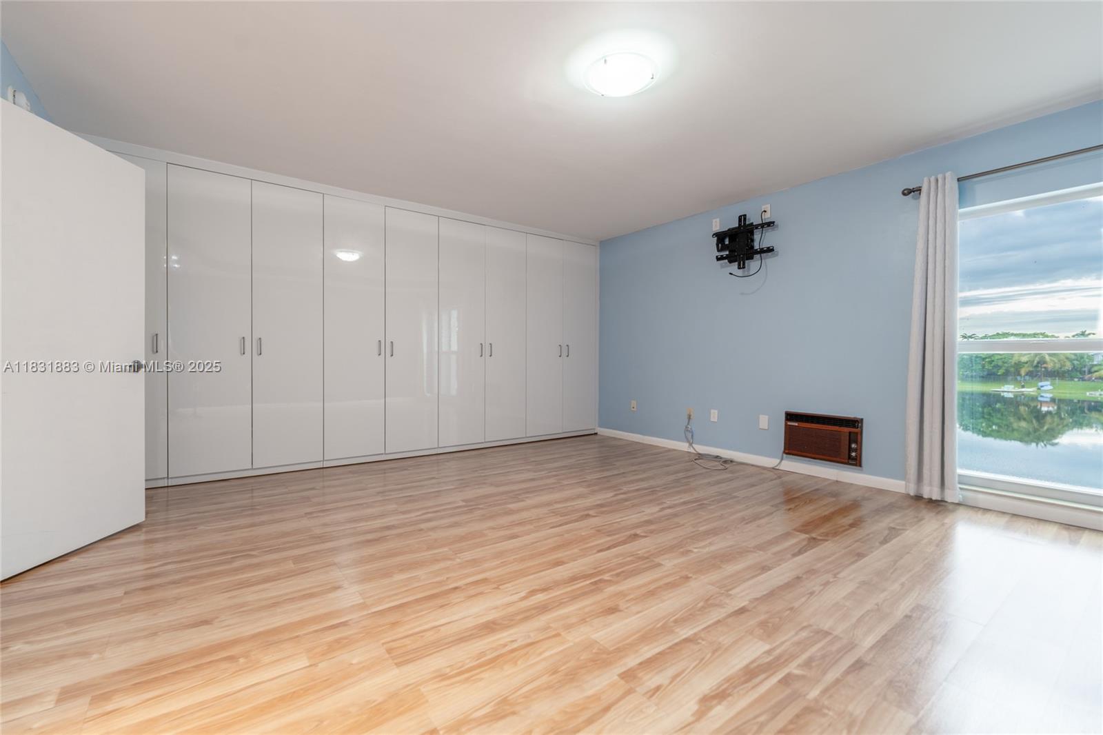 13949 Southwest 84th Street, Unit 801 Miami, FL 33143 - Photo 6 of 38 a view of empty room with wooden floor and fan