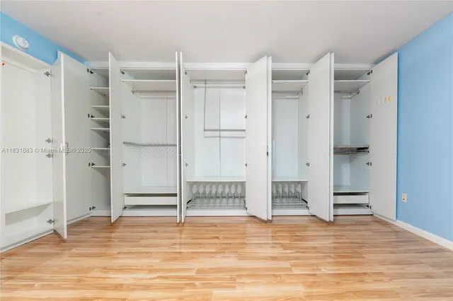 a view of empty room with wooden floor and white cabinet