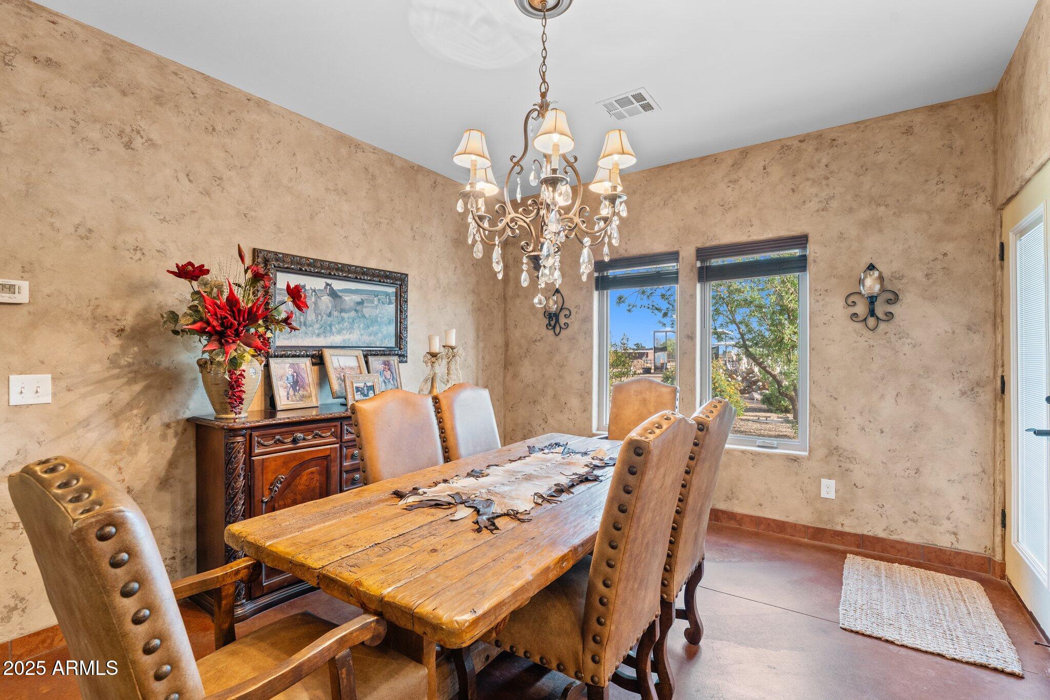 17789 West Peak View Road Surprise, AZ 85387 - Photo 17 of 69 a view of a dining room with furniture a chandelier and wooden floor