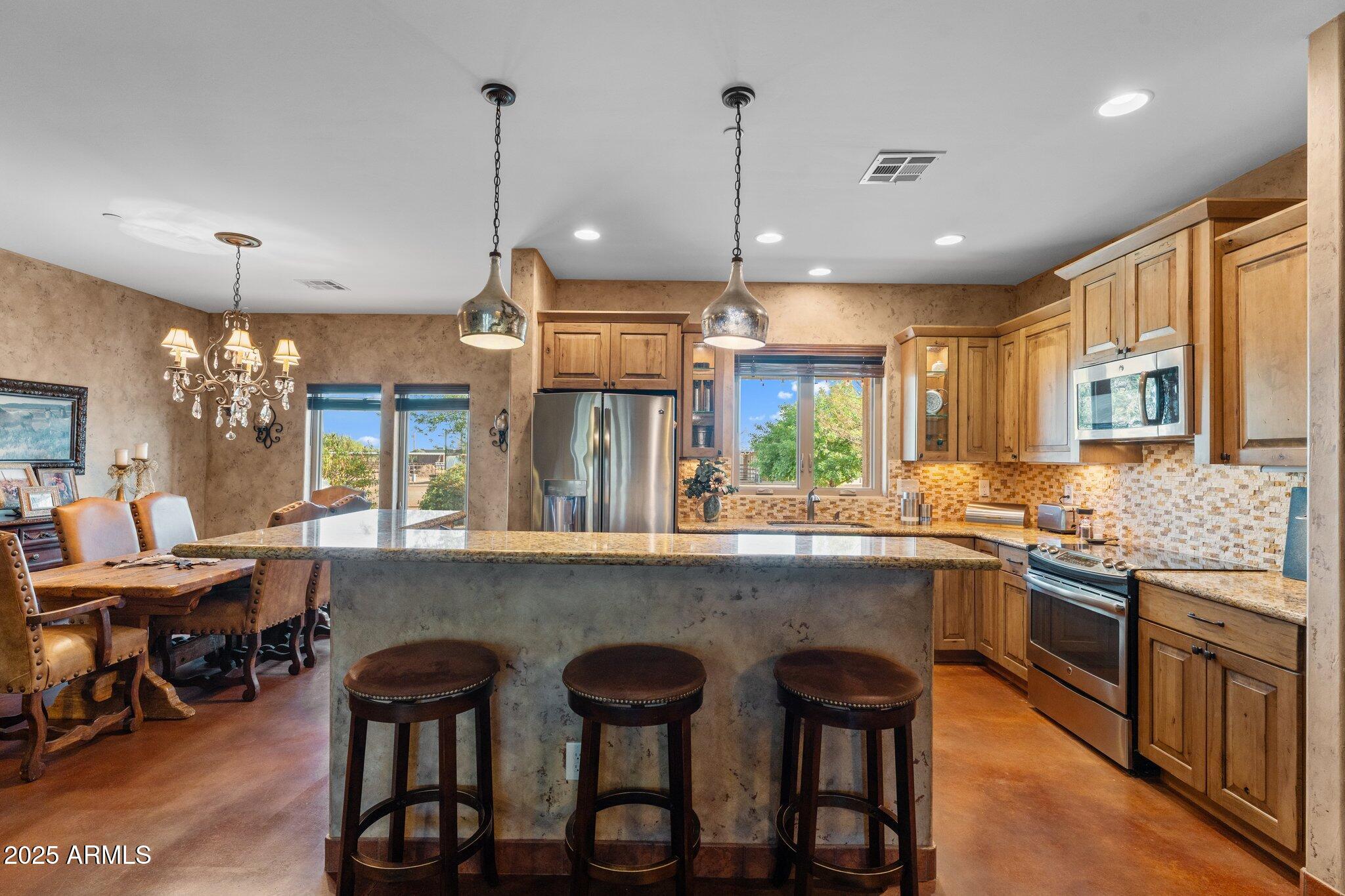 17789 West Peak View Road Surprise, AZ 85387 - Photo 21 of 69 a kitchen with lots of counter space dining table and chairs
