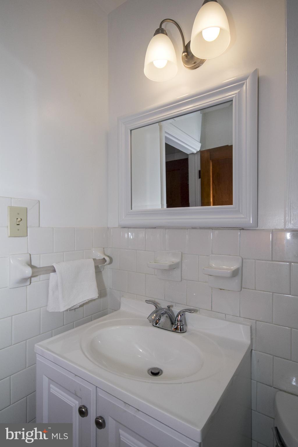 4113 Raleigh Road Baltimore, MD 21207 - Photo 14 of 23 a bathroom with a sink and a mirror