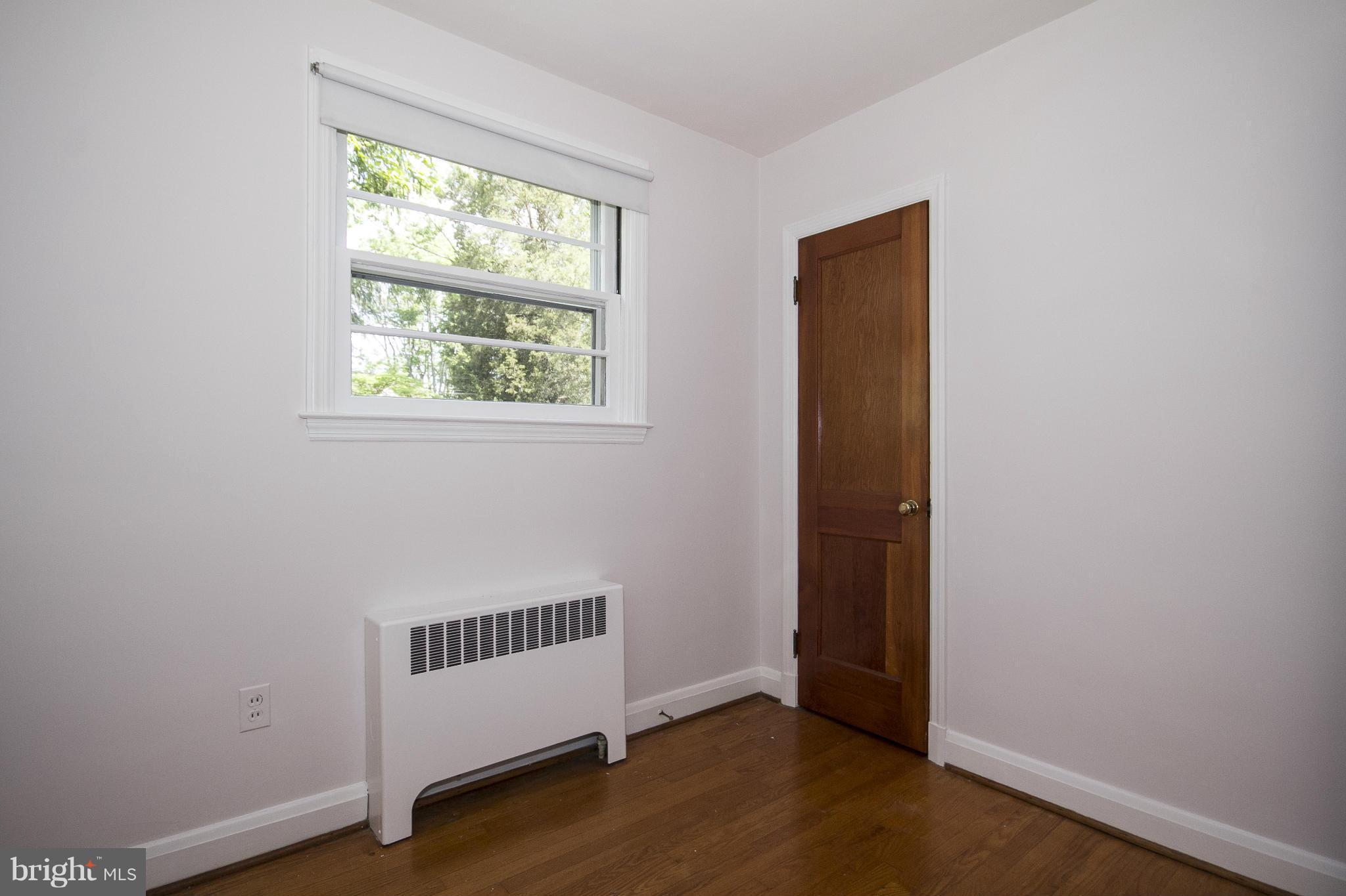 4113 Raleigh Road Baltimore, MD 21207 - Photo 15 of 23 an empty room with wooden floor and windows
