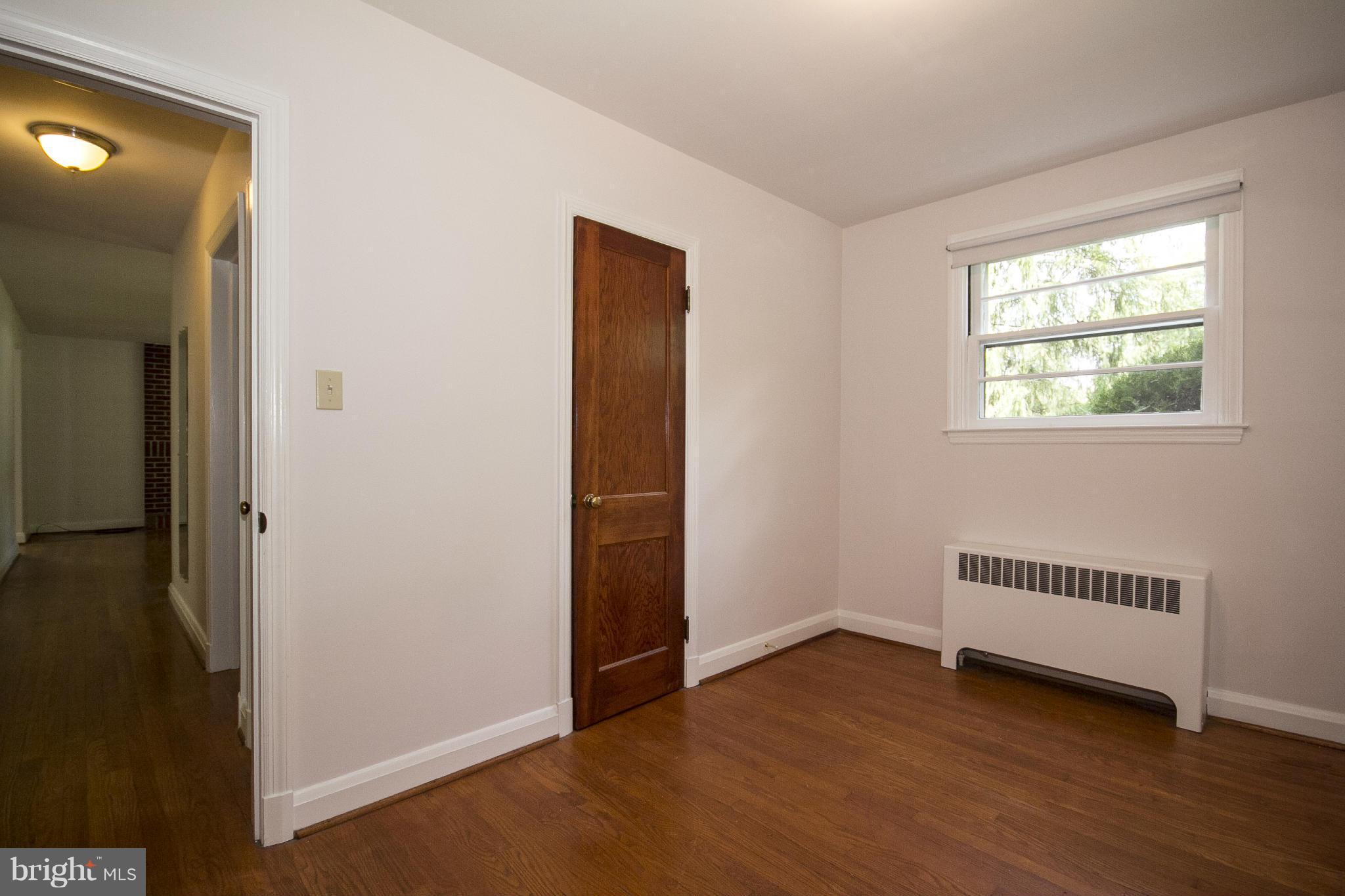 4113 Raleigh Road Baltimore, MD 21207 - Photo 16 of 23 a view of an empty room with wooden floor and a window