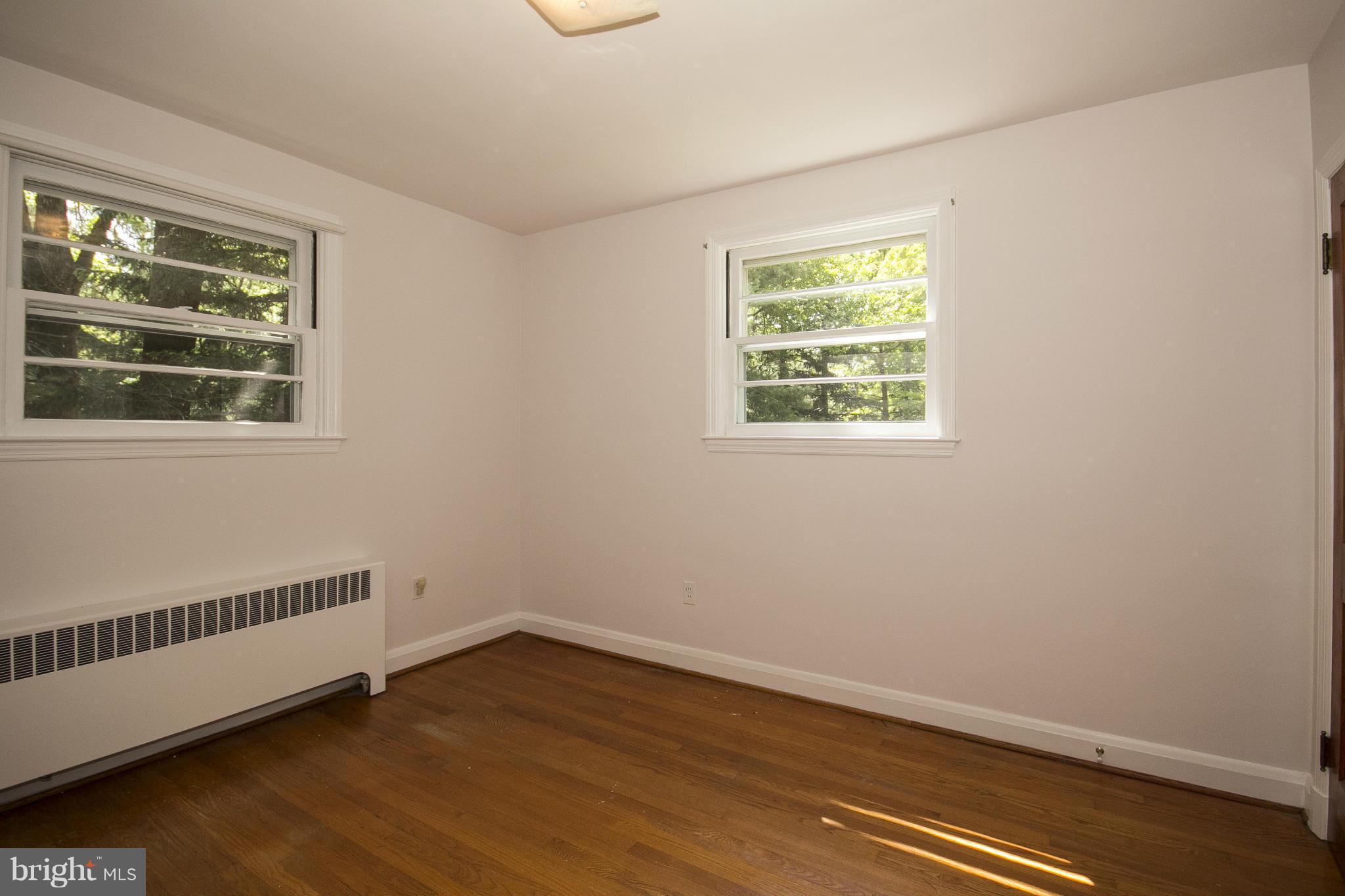 4113 Raleigh Road Baltimore, MD 21207 - Photo 17 of 23 a view of an empty room with wooden floor and a window
