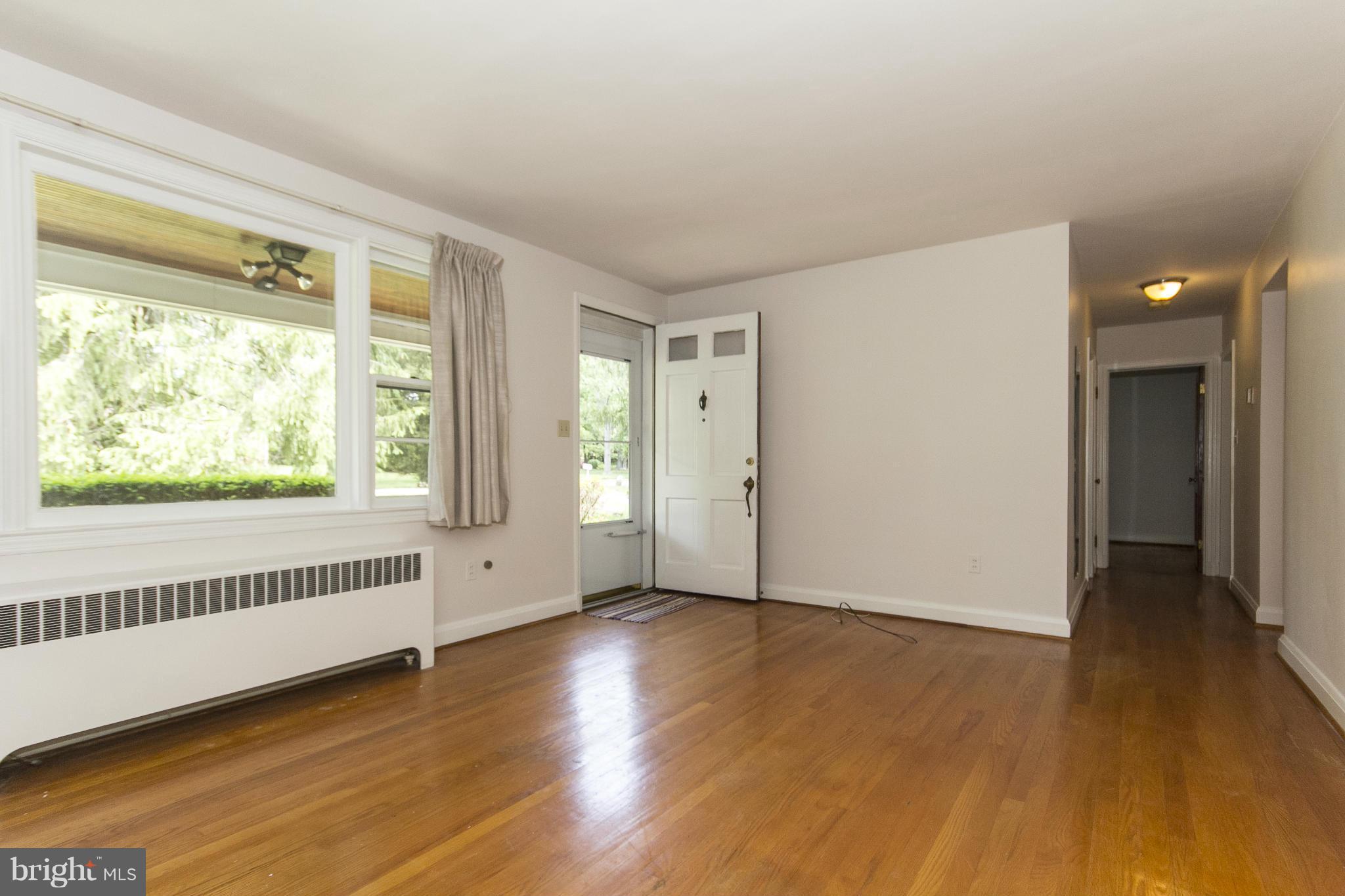 4113 Raleigh Road Baltimore, MD 21207 - Photo 8 of 23 an empty room with wooden floor and windows