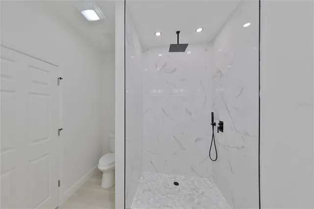 a bathroom with a shower a toilet and a shower