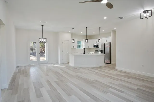 a view of a kitchen with wooden floor and windows