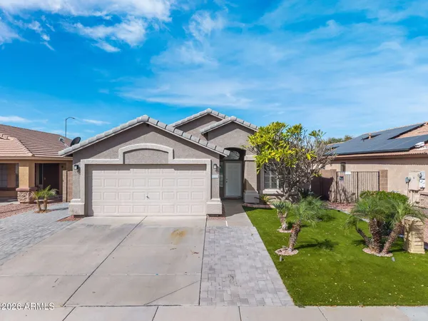 a view of a house with a small yard plants and a large tree