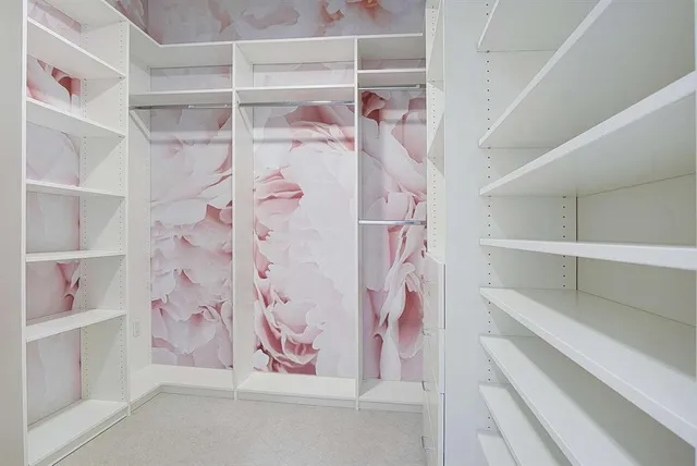 a bedroom with a bed and a potted plant on dresser