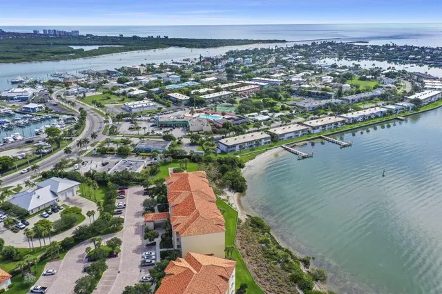 an aerial view of a city with lots of residential buildings ocean and mountain view