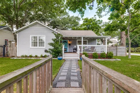 a front view of a house with a yard and potted plants