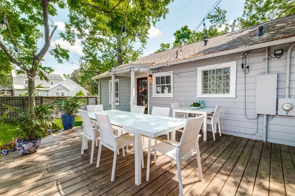 a view of a patio with table and chairs and potted plants with wooden floor and fence
