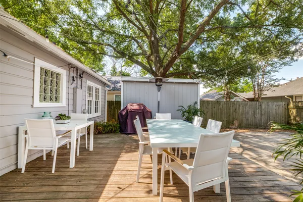 a view of a patio with table and chairs with wooden floor and fence