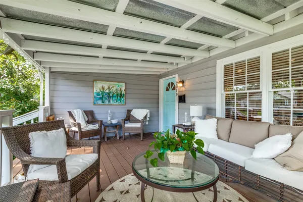 a living room with patio furniture and a potted plants