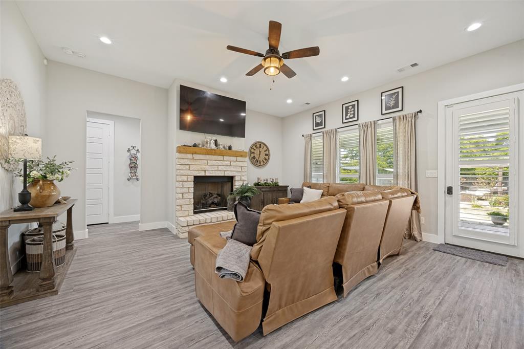1105 Ranch Drive Bonham, TX 75418 - Photo 2 of 25 Spacious living area featuring a floor-to-ceiling brick fireplace with a wood mantel, wood-finish flooring, recessed lighting, and a ceiling fan