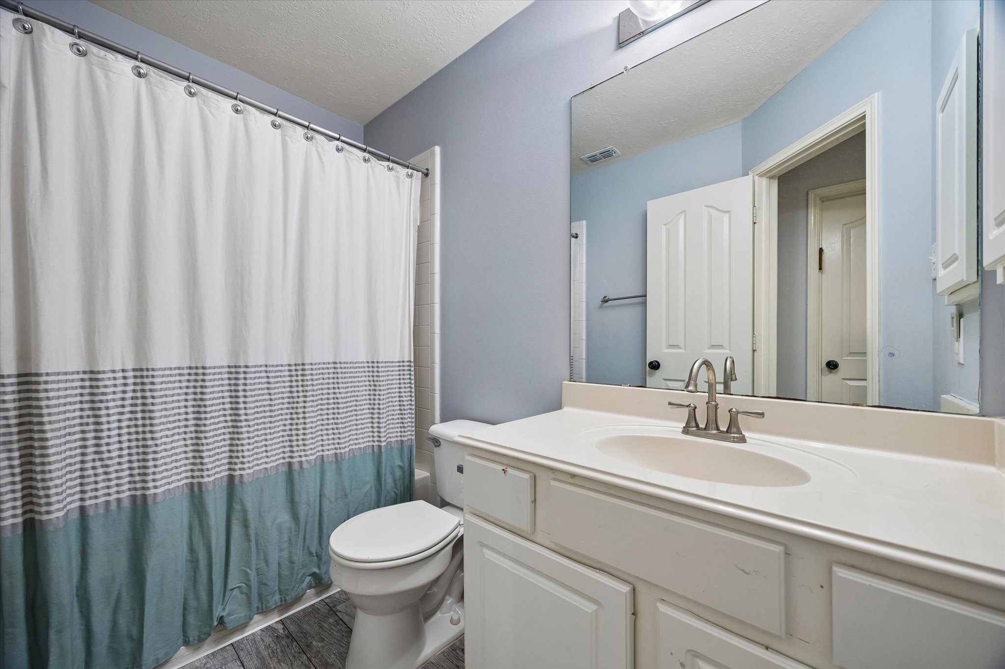 8123 Clarion Way Houston, TX 77040 - Photo 23 of 33 a bathroom with a sink a toilet and shower curtain