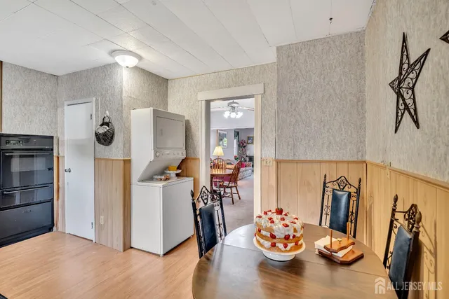 a kitchen with stainless steel appliances wooden floor dining table and chairs