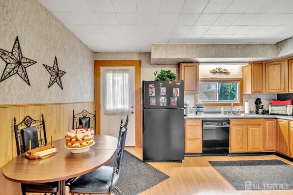 a kitchen with stainless steel appliances granite countertop a refrigerator a stove a sink dishwasher with a dining table and chairs