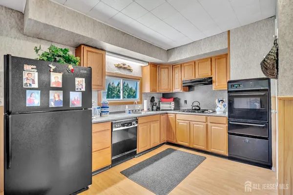 a kitchen with stainless steel appliances granite countertop a stove a sink dishwasher and a refrigerator