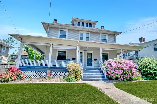 a front view of a house with a garden and yard