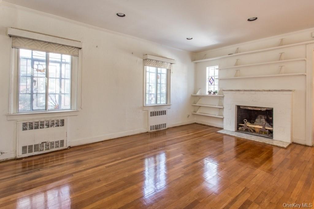 186-18 Cambridge Road Queens, NY 11432 - Photo 1 of 1 a view of empty room with wooden floor and fireplace