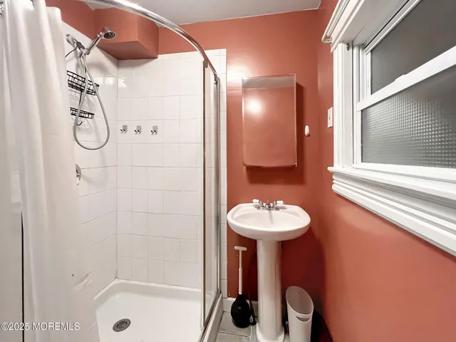 a bathroom with a sink a mirror and shower