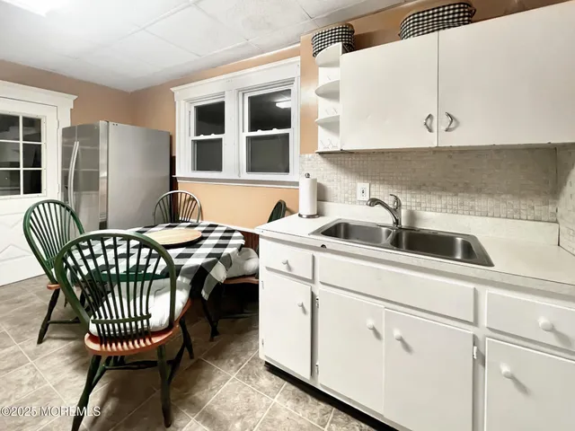 a kitchen with a sink a table and chairs