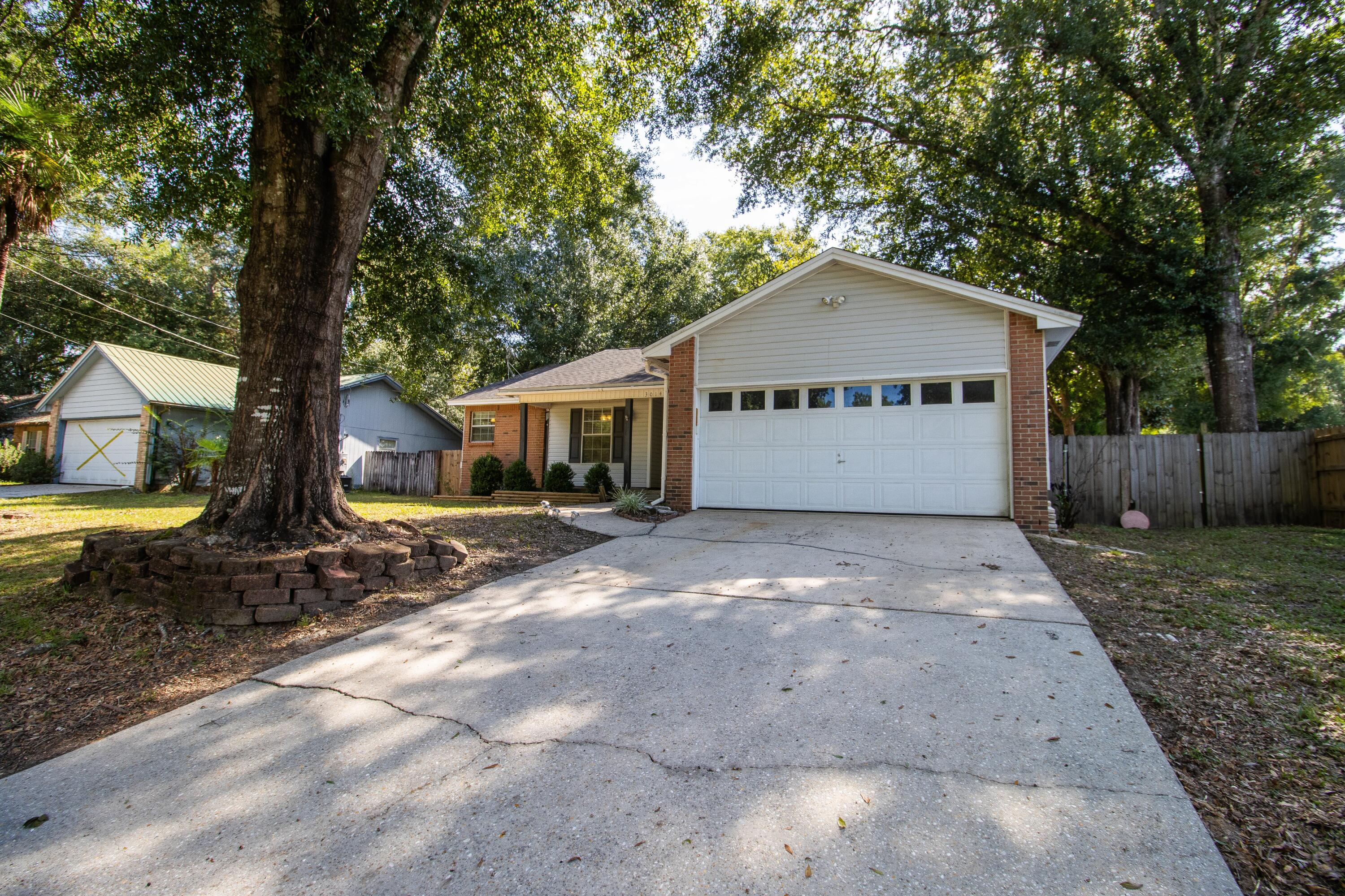 a front view of a house with a yard and tree s