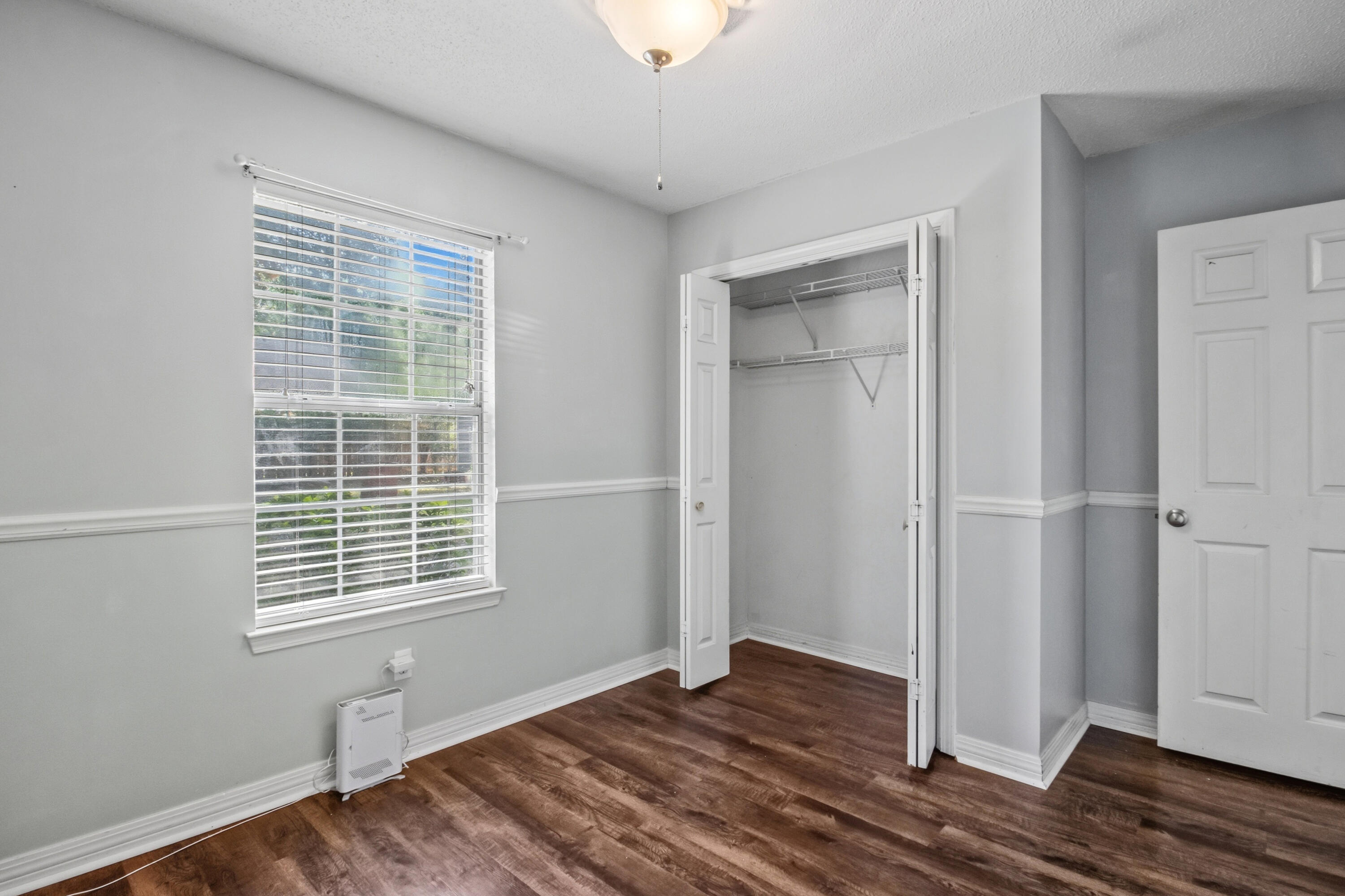 3014 Windsor Circle Crestview, FL 32539 - Photo 12 of 26 a view of an empty room with wooden floor and a window
