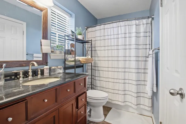 a bathroom with a granite countertop sink toilet and shower