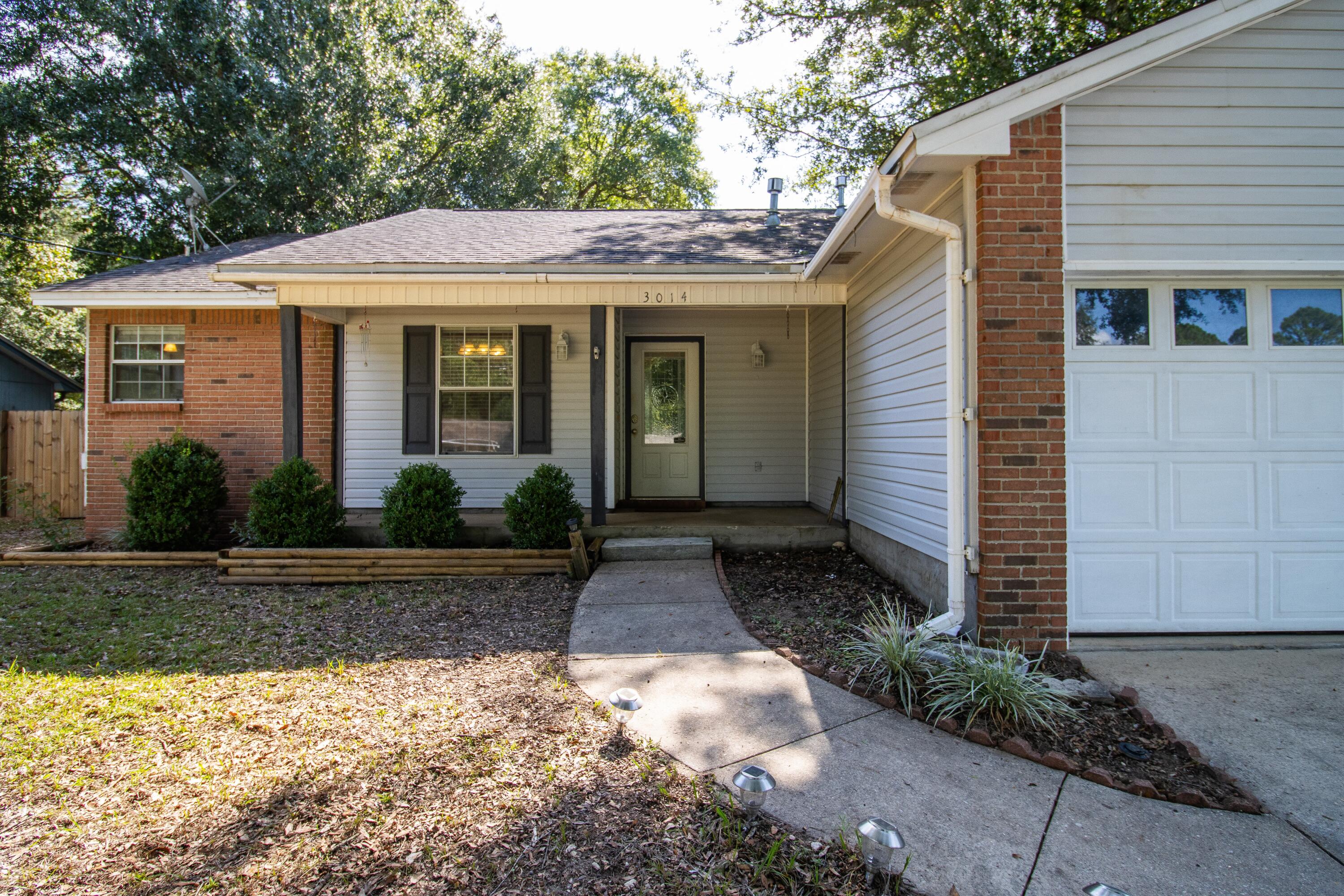 3014 Windsor Circle Crestview, FL 32539 - Photo 24 of 26 a view of a white house with a small yard plants and large tree