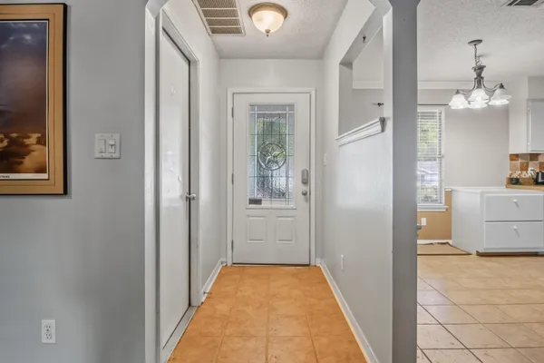 a view of a hallway view with wooden floor and a living room