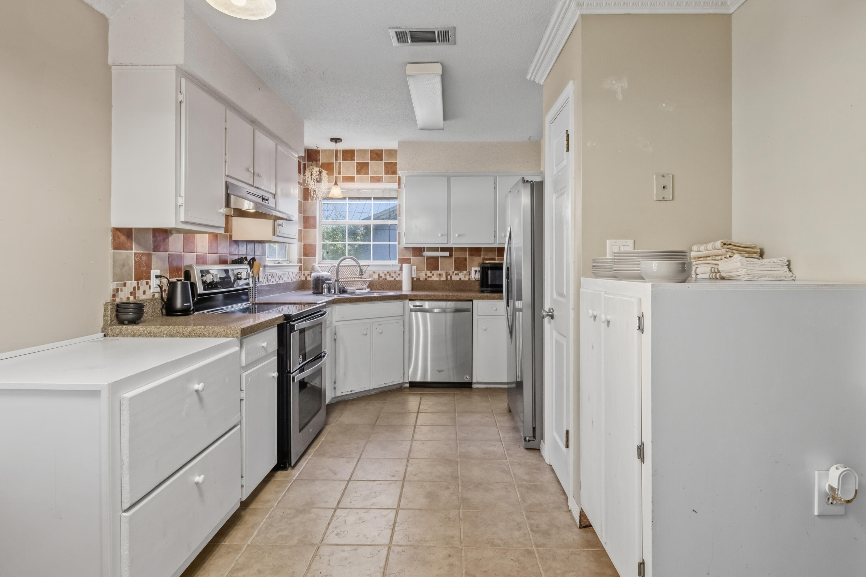 3014 Windsor Circle Crestview, FL 32539 - Photo 5 of 26 a kitchen with white cabinets and white appliances