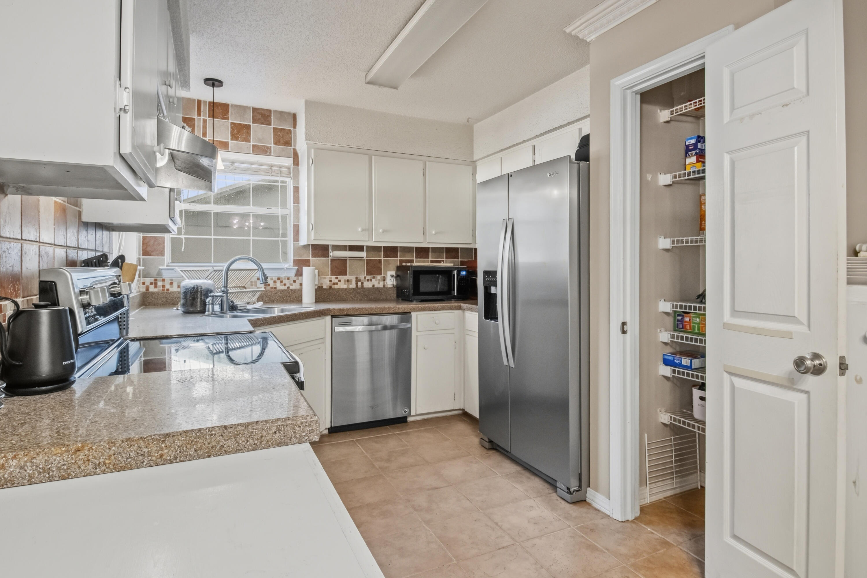 3014 Windsor Circle Crestview, FL 32539 - Photo 6 of 26 a kitchen with white cabinets and stainless steel appliances