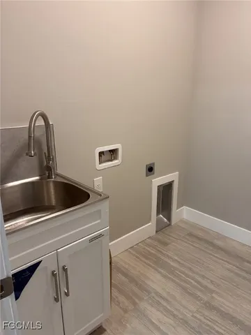 a close view of a sink and dishwasher with wooden floor