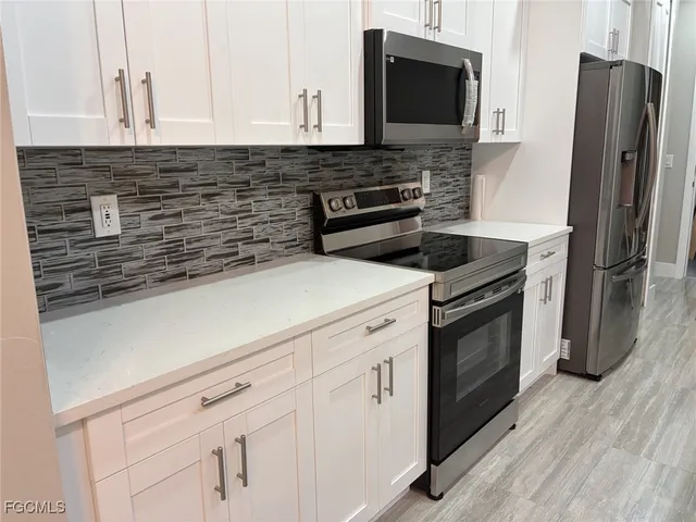 a kitchen with stainless steel appliances white cabinets and a stove