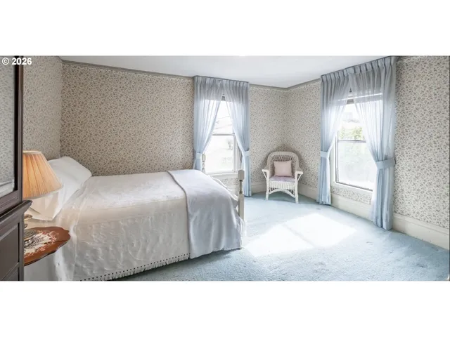 a bedroom with a bed chair and window