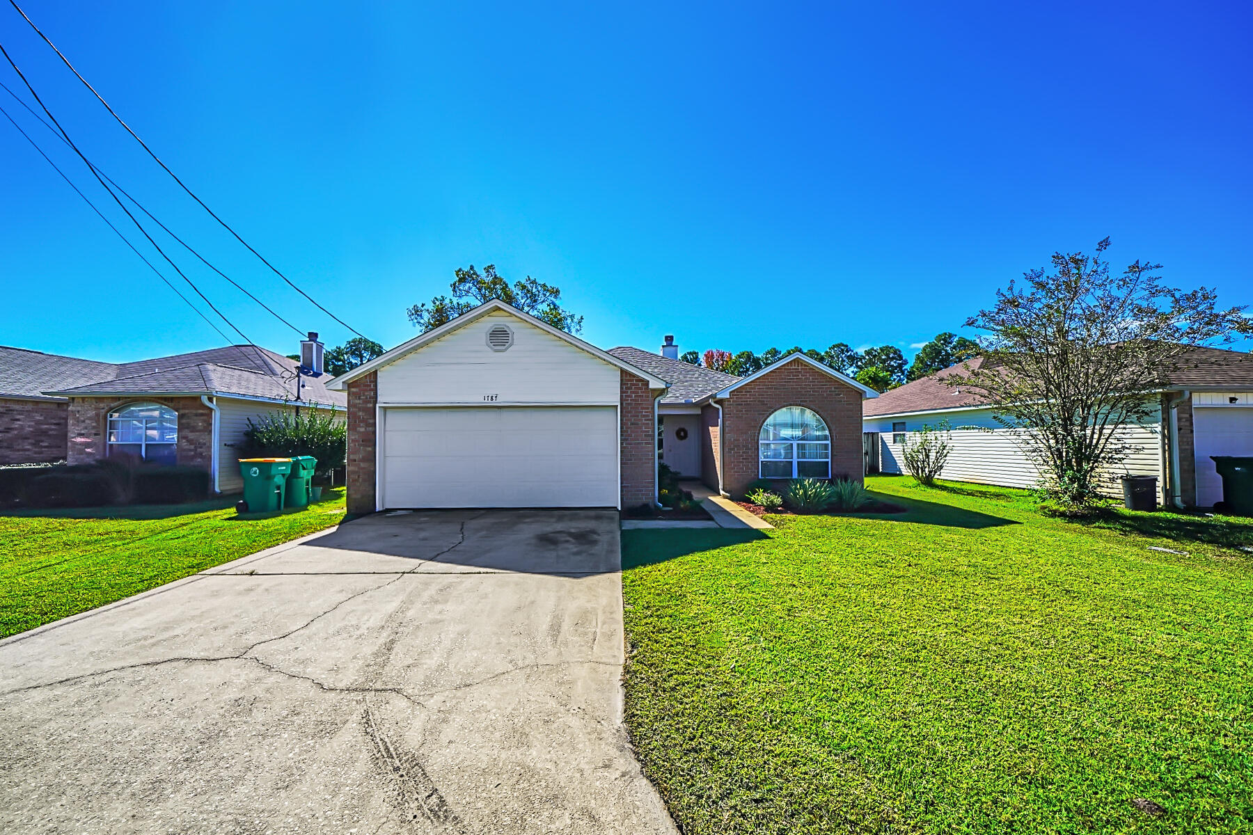 1787 Old Ranch Road Fort Walton Beach, FL 32547 - Photo 23 of 25 a front view of a house with a yard and garage