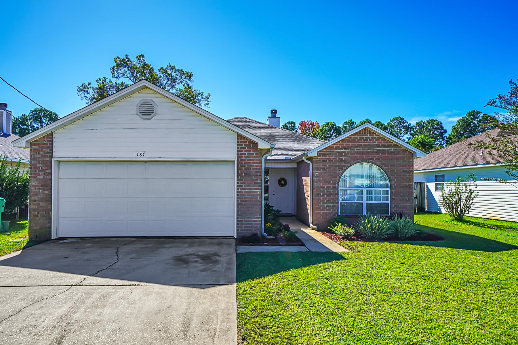 1787 Old Ranch Road Fort Walton Beach, FL 32547 - Photo 24 of 25 a front view of a house with a yard and garage