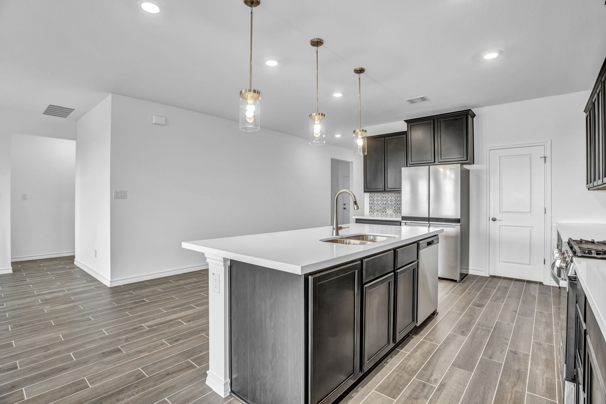 131 Adeline Road Hutto, TX 78634 - Photo 17 of 30 A well-appointed kitchen showcasing a spacious island and gleaming stainless steel appliances.