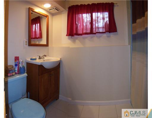2 Rugby Road Colonia, NJ 07067 - Photo 12 of 15 a bathroom with a toilet a sink and mirror