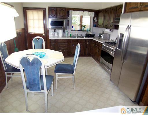 2 Rugby Road Colonia, NJ 07067 - Photo 3 of 15 a kitchen with stainless steel appliances granite countertop a sink a stove a table and chairs