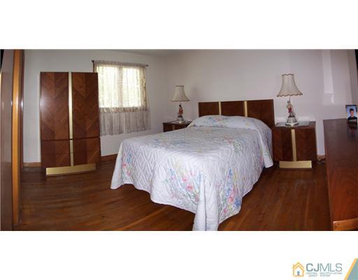 2 Rugby Road Colonia, NJ 07067 - Photo 7 of 15 a bedroom with a bed and wooden floor