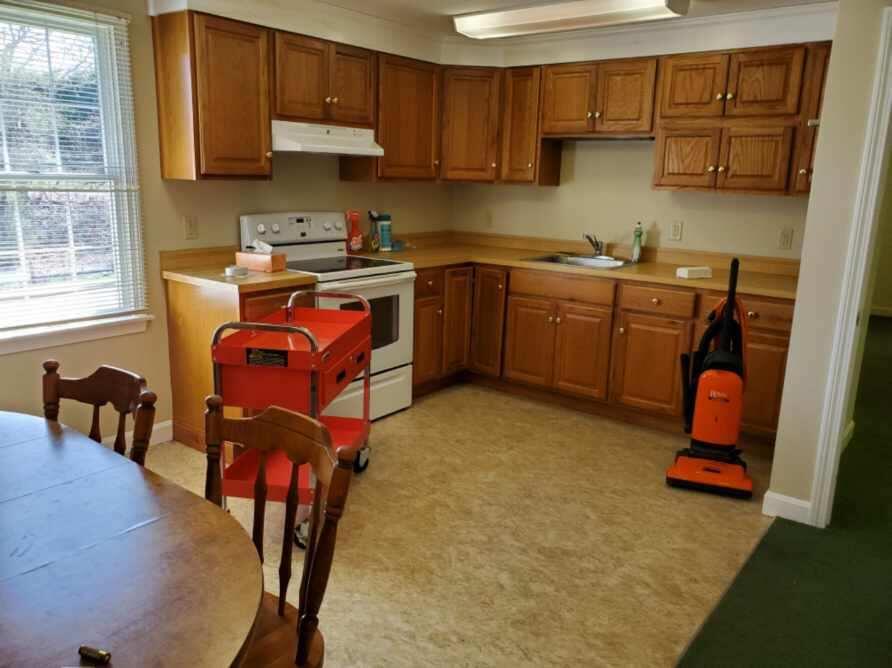 250-252 Underpass Road Brewster, MA 02631 - Photo 12 of 30 a kitchen with stainless steel appliances granite countertop a sink a stove a dining table and chairs with wooden floor
