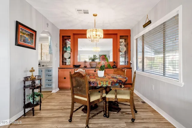 a dining room with furniture a chandelier and wooden floor