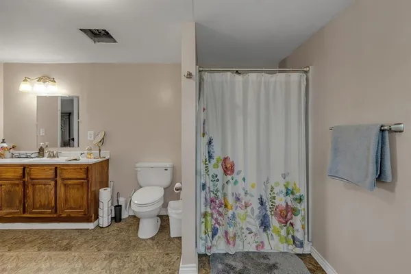a bathroom with a toilet sink and shower curtain