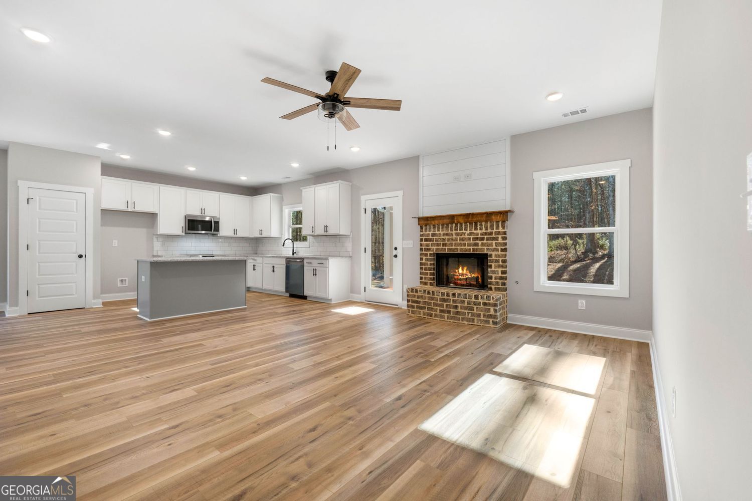 1578 English Road Forsyth, GA 31029 - Photo 16 of 40 a view of a kitchen and an empty room with wooden floor kitchen view