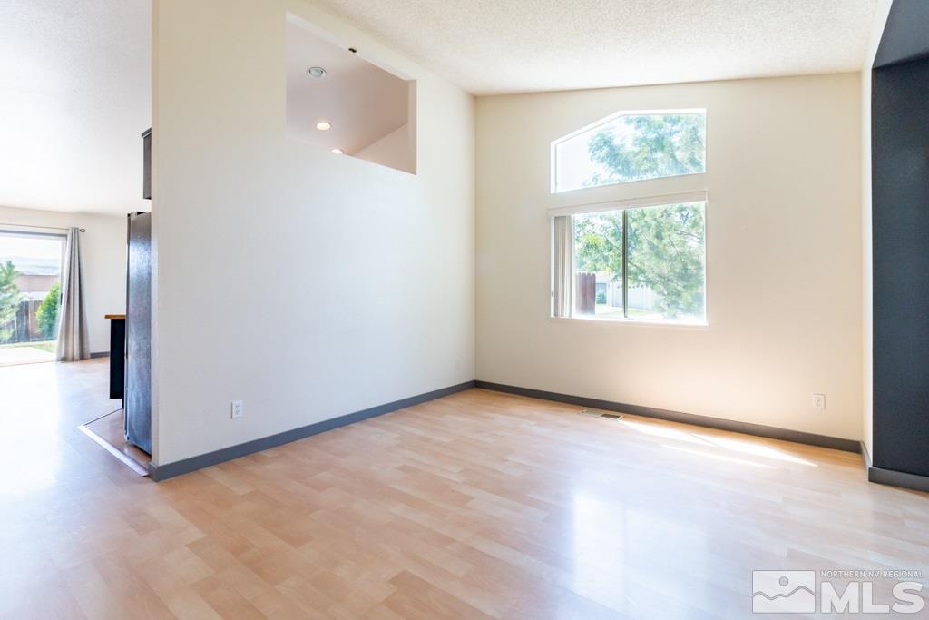 7540 Devonshire Lane Reno, NV 89511 - Photo 4 of 25 an empty room with wooden floor and a window