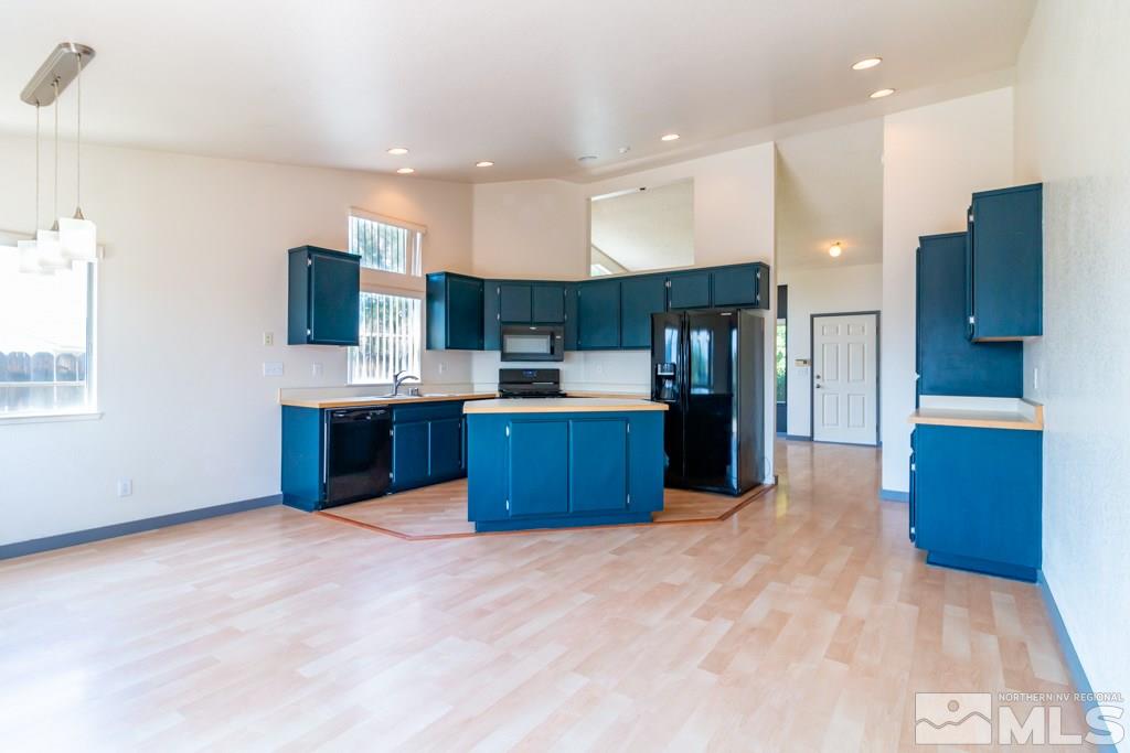 7540 Devonshire Lane Reno, NV 89511 - Photo 6 of 25 a kitchen with stainless steel appliances kitchen island granite countertop a stove and a refrigerator